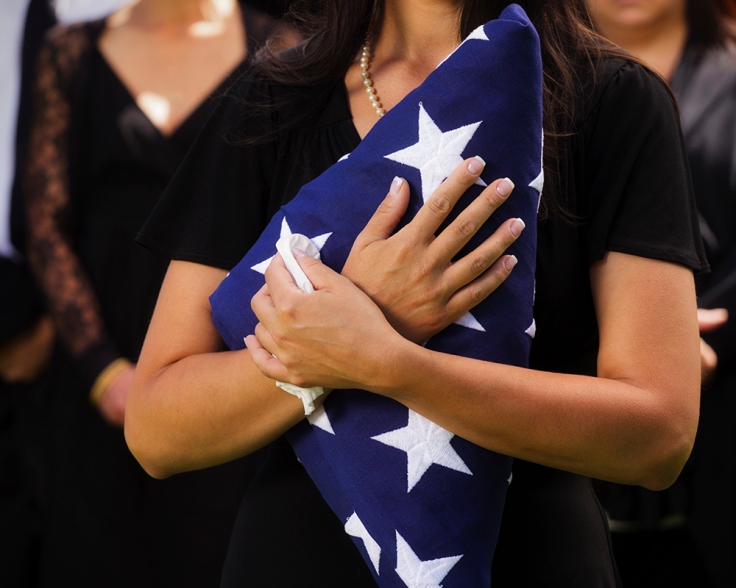 Woman Holding Flag at a Funeral